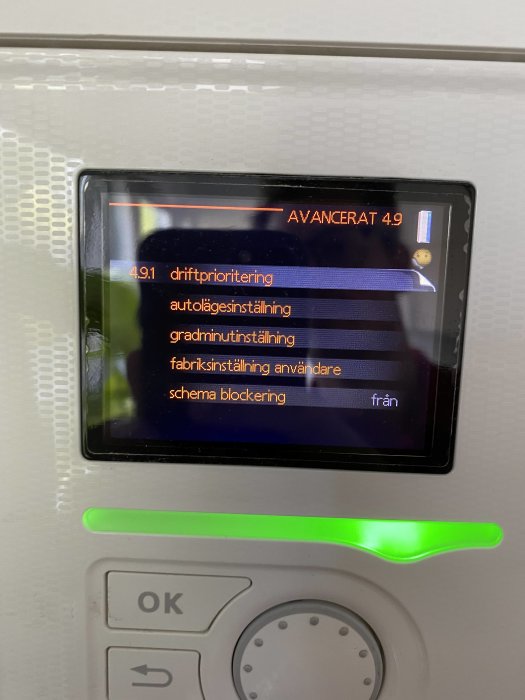 Digital display med menyalternativ för driftinställningar på en värmepump eller liknande apparat.