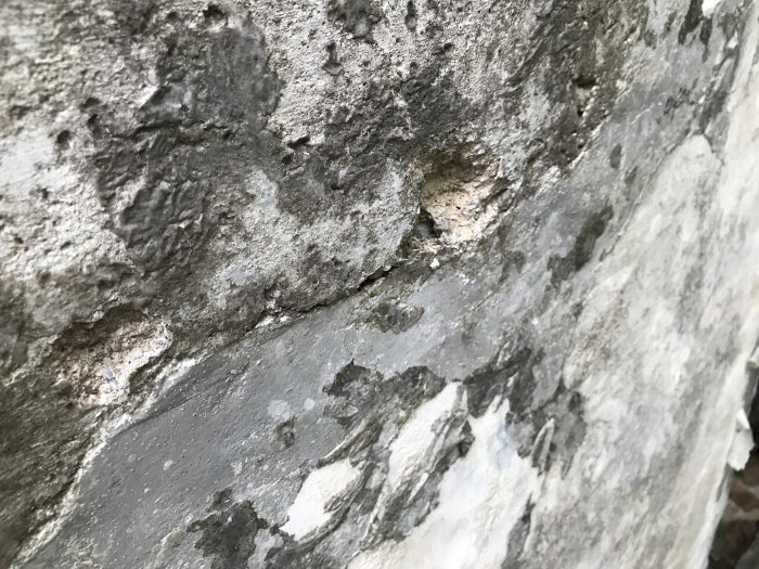 Närbild av sliten betongtrappa som behöver repareras, med synliga sprickor och avflagningar.