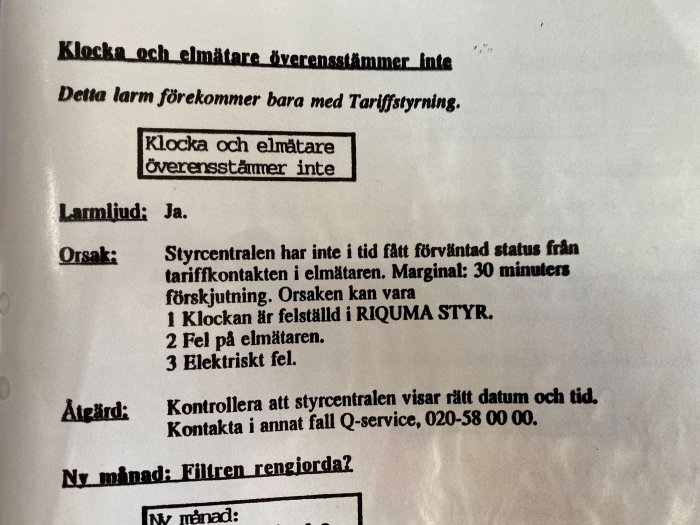 Fotografi av en manual med instruktioner för felsökning av larm, inklusive orsaker och åtgärder.