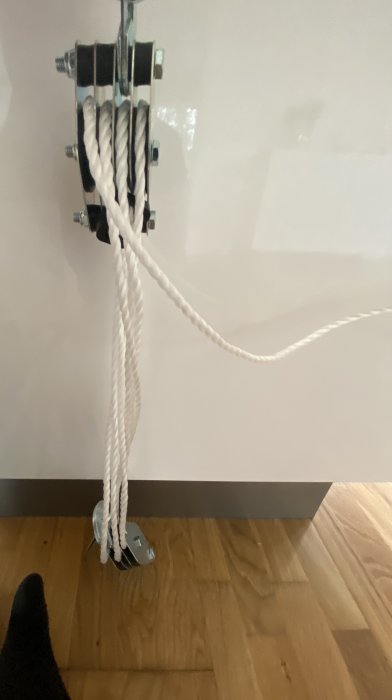 Ett rep genom ett block som är fastsatt på väggen för att förbättra ergonomin vid dragning.