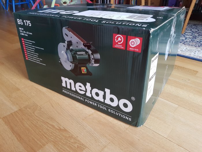 Metabo bandslipmaskin BS 175 i förpackning på trägolv i ett hem.