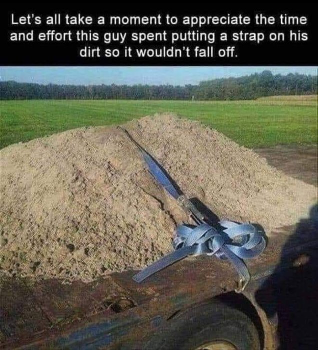 En lastbilsflak fullt med jord säkrat med en spännrem för att förhindra spill.