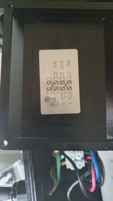 Elanslutningar för en poolpump med en diagrametikett och färgkodade kablar kopplade till en terminal.
