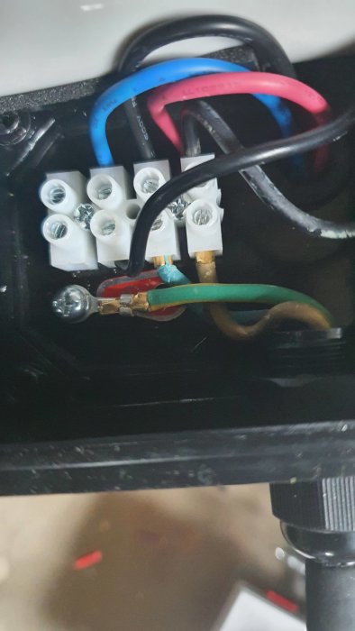 Elektriska kablar anslutna till en kontaktdosa, med en osäker installation av en ny poolpump.