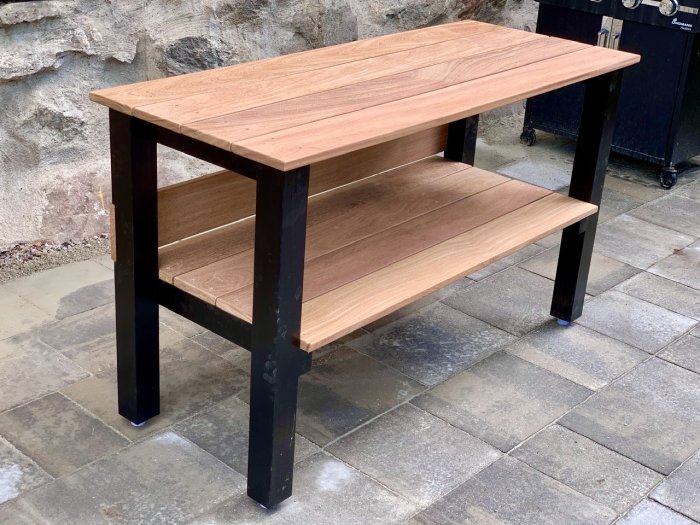 Handbyggt sillbuffébord av cumaru-trä och svartmålade granreglar med återanvända dörrstopp som fötter.