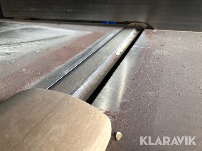 Sågblad på ett bordssågverktyg täckt med sågspån.
