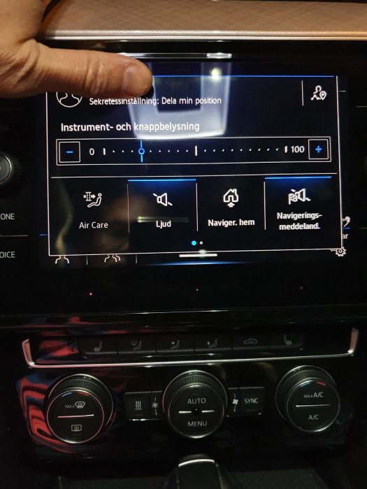 Bilens infotainmentsystem med en öppen sekretessinställningsmeny och en hand som pekar på skärmen.