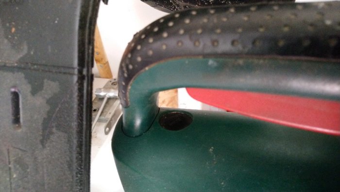 Närbild av en handtaget på en grön och röd Bosch-elverktyg med synligt slitage och potentiell skada.