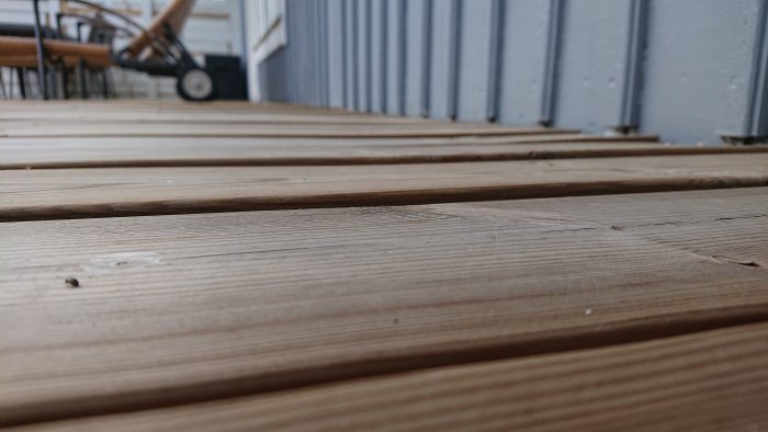 Trädäck med uppstickande skruvar och upphöjningar i trallen.