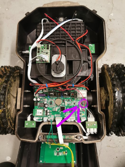 Öppnat elektroniskt fordon visar moderkort med markerad högtalare/buzzer klädd för ljuddämpning.