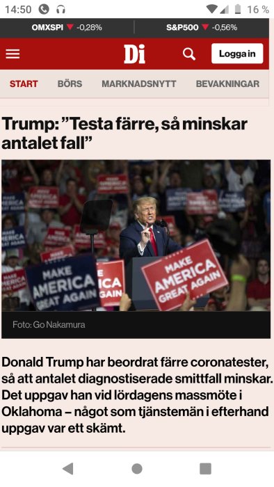 Person talar vid politiskt kampanjmöte med publik och "Make America Great Again" skyltar.