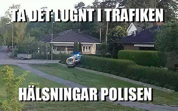 Polisbil av vägen på en gräsmatta, med texten "Ta det lugnt i trafiken. Hälsningar polisen".