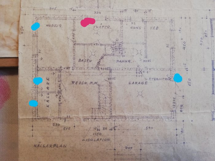 Gammal arkitektritning av källarplan med markerade ventilationer, tilluft blå och frånluft röd.