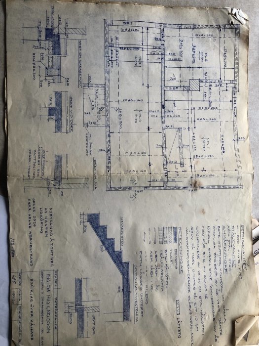 Äldre byggritning över källare med olika mått och markeringar, slitet och veckat dokument.