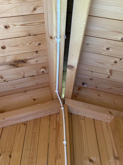 Interiör av förrådstaknock i vinkel med synliga träbjälkar och isoleringsmaterial.
