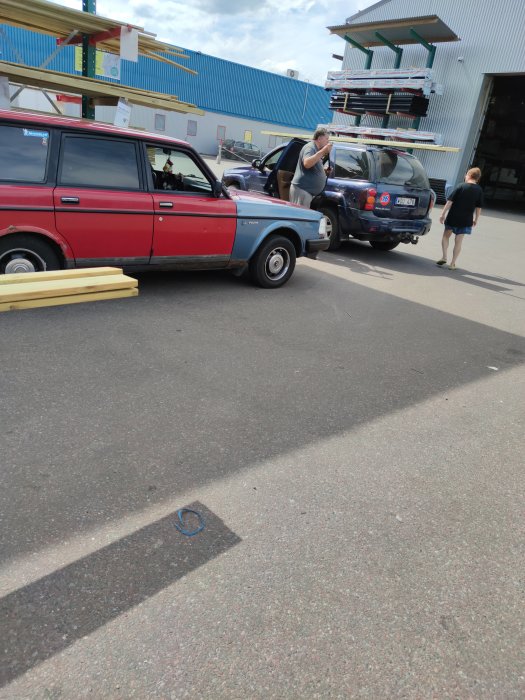 Person säkrar last på taket av en SUV utanför en byggvaruhandel med hjälp av ett spännband.