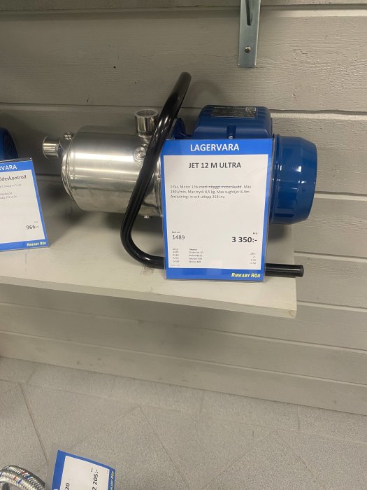 Blå Jet 12 M Ultra pump utställd på hylla med teknisk specifikation och pris.