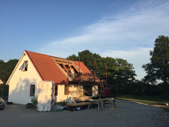 Hus under renovering med delvis avlägsnat tak i soligt väder.