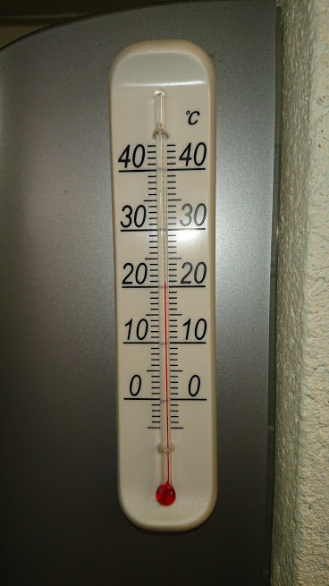 En väggmonterad termometer som visar cirka 20 grader Celsius inomhus.