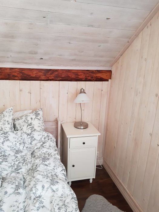 Renoverat sovrum med träpanelväggar och vitt tak behandlat med linolja och balsamterpentin.