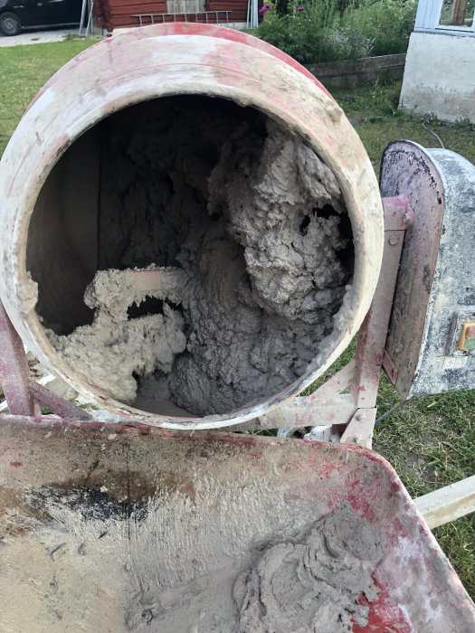 Tjock, klumpig puts i en cementblandare och på en skottkärra, redo för att knådas till rätt konsistens för byggprojektet.