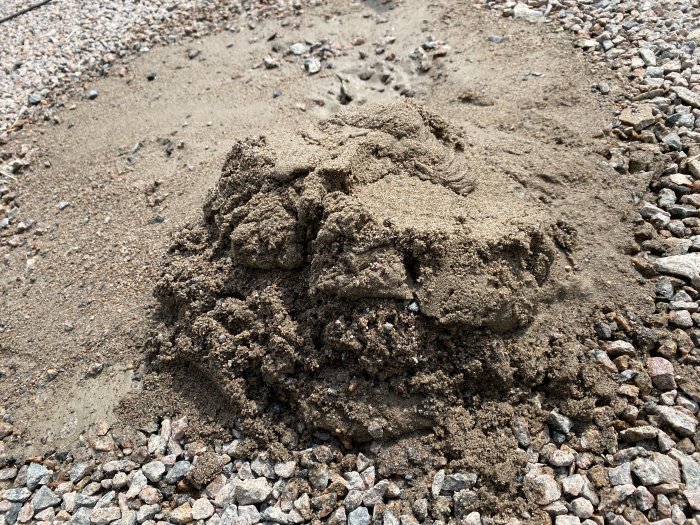 En hög med sand och grus på hårt underlag, tyder på återkommande utgrävning utan framsteg.