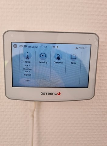 Östberg Heru 100s FTX-systemets kontrollpanel visar temperatur och fläktinställningar på en vit vägg.