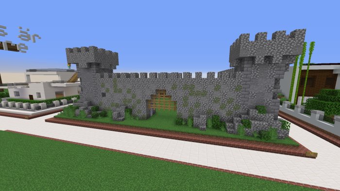 Minecraft-skärmbild med stenmur och moderna hus i bakgrunden.