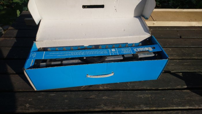 Geringssåg i öppnad blå förpackning på träyta, inkluderar extra sågblad med ytrost.