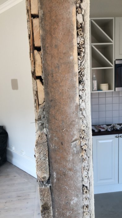 Renoveringsprojekt där en halvöppnad vägg med vertikala och stora träplankor avtäcks.