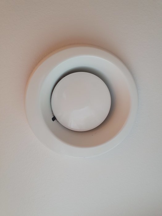 Takmonterad rund ventilationsgrill som är stängd, på vit bakgrund.