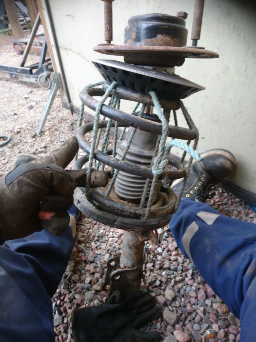 Person genomför ett belastningstest på ett rep fastsurrat runt en metallkonstruktion.