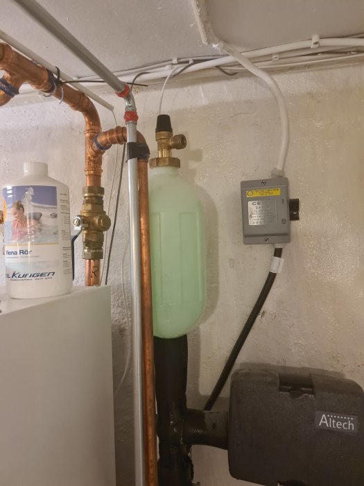 Expansionskärl för bergvärme fullt med vätska som läcker på en betongvägg.