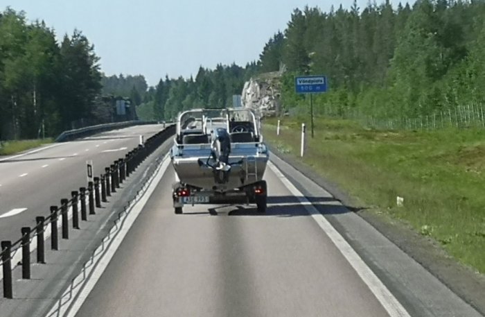 Motorbåt på en trailer som ser ut att köra av sig själv på motorvägen.