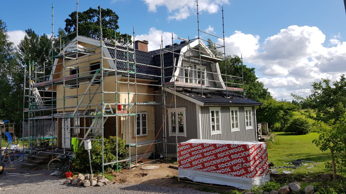 Huset under renovering med ställningar, tillbyggnad av sovrum och badrum syns.