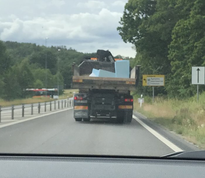 Lastbil med XPS-skivor på flak på väg, skivorna ligger stabilt trots fart på 90 km/h.