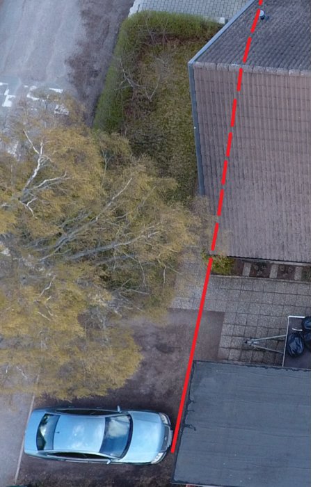 Luftbild på ett hus med markerad tänkt dräneringslinje utmed byggnadens sula och planerad parkeringsplats.