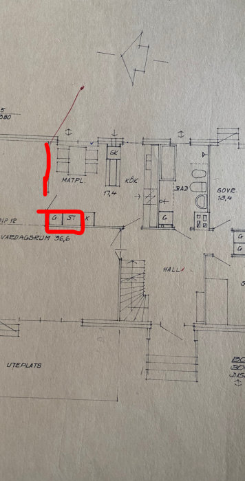 Ritning av en bostadsplan med röd markering kring ett område i vardagsrummet som användaren önskar ta bort.