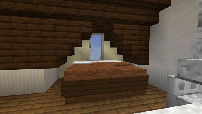 Minecraft-byggprojekt med en säng, fönster och trappanordning i ett hus.