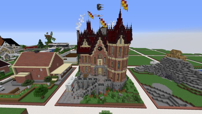 Minecraft-skapelse av ett detaljerat slott med torn och flaggor, omgivet av andra byggnader och landskap.