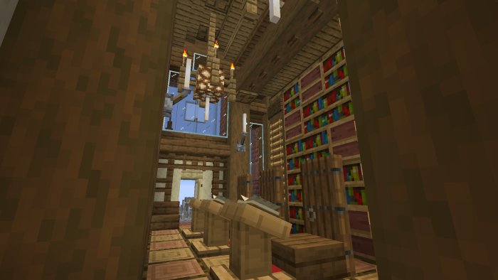 Interiör av pixelerad bibliotekshörna med bokhyllor och ljuskrona från spelet Minecraft.