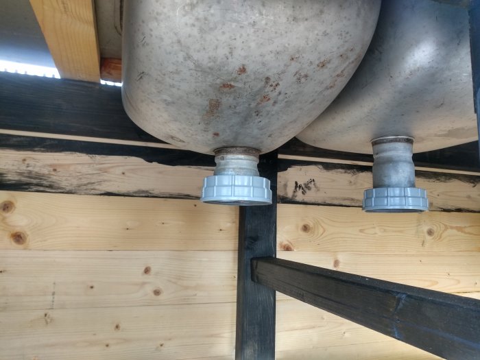 Rostfri vask ansluten med PVC-adapter till avloppsrör i en konstruktion för utekök.