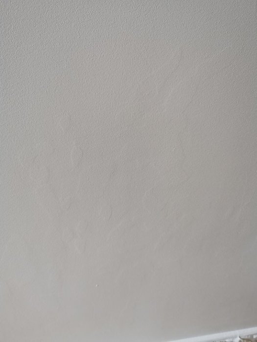 Nygrundad vägg med synliga spackelområden efter bred- och punktspackling.