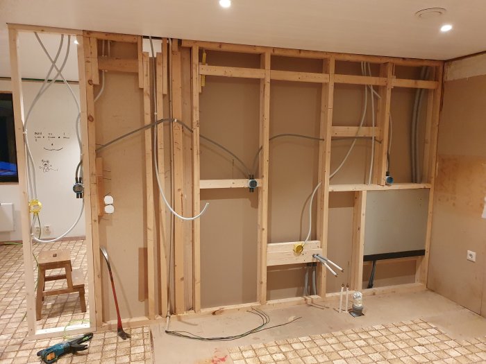 Renoveringsarbete med uppreglade väggar och eldragning i ett hus under ombyggnad.