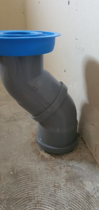 Avloppsrör böjt mot väggen installerat på ett golv, fråga om korrekt skarvning för handfat.