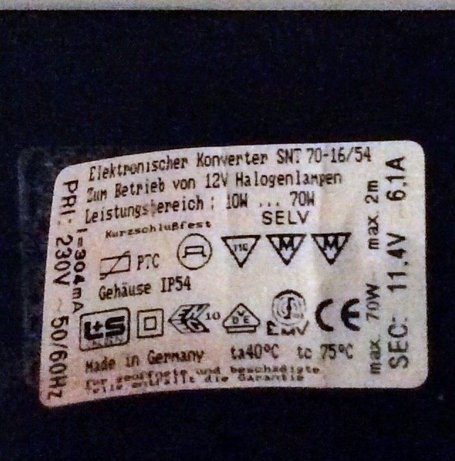 Etikett på ett elektroniskt drivdon för 12V halogenlampor med tekniska specifikationer och IP54 klassificering.