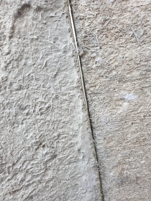 En närbild av en ca 3mm bred glipa mellan två betongblock i en grundkonstruktion.
