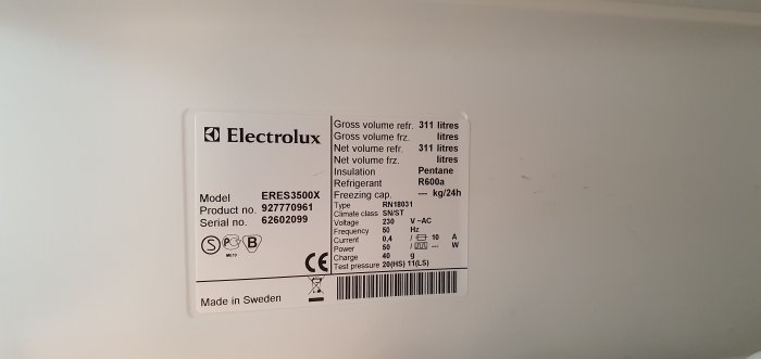 Typskylt på Electrolux-kylskåp modell ERES3500X som visar modell, produktnummer och tekniska specifikationer.