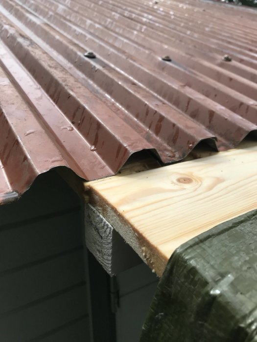 Brun plåttak som inte möter trälist korrekt och skapar en oönskad öppning.