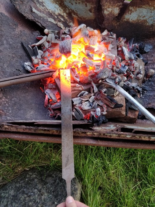 Eldstad med glödande kol och en smidesjärn värms upp.